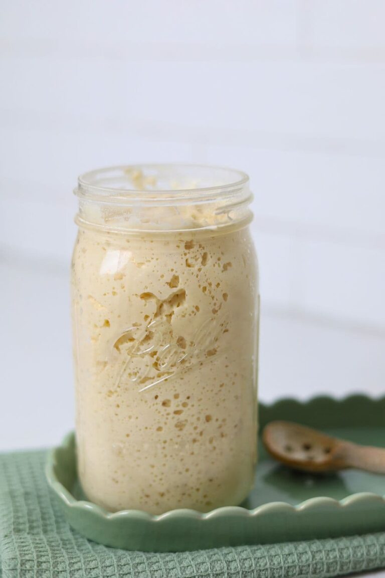 A large jar full of bubbly sourdough starter.