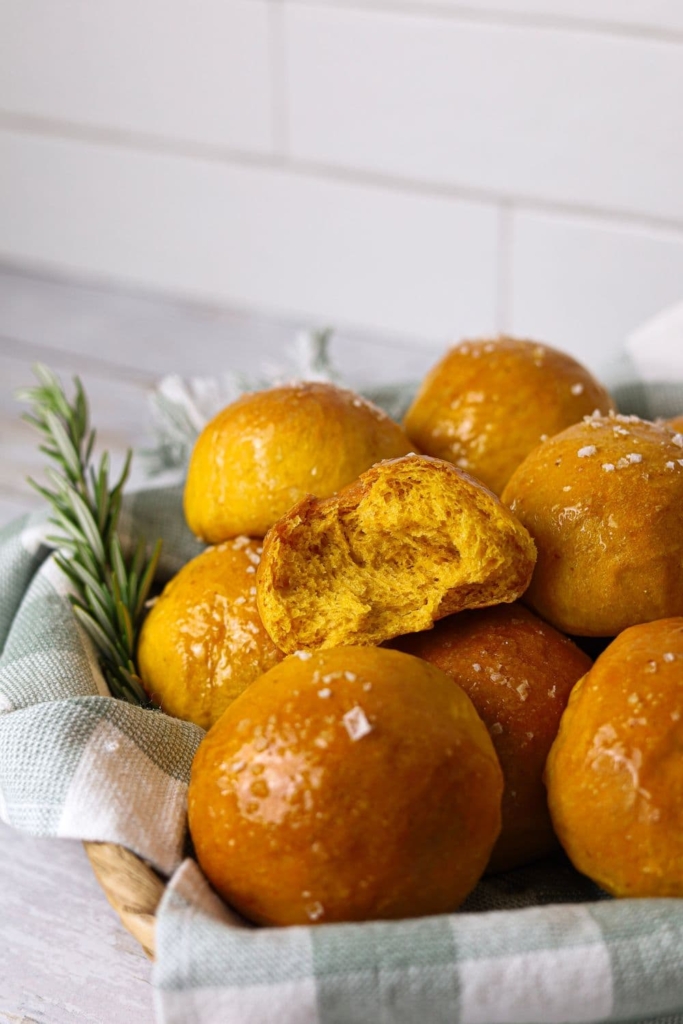 A basket of sourdough pumpkin dinner rolls ready to be served at Thanksgiving dinner.