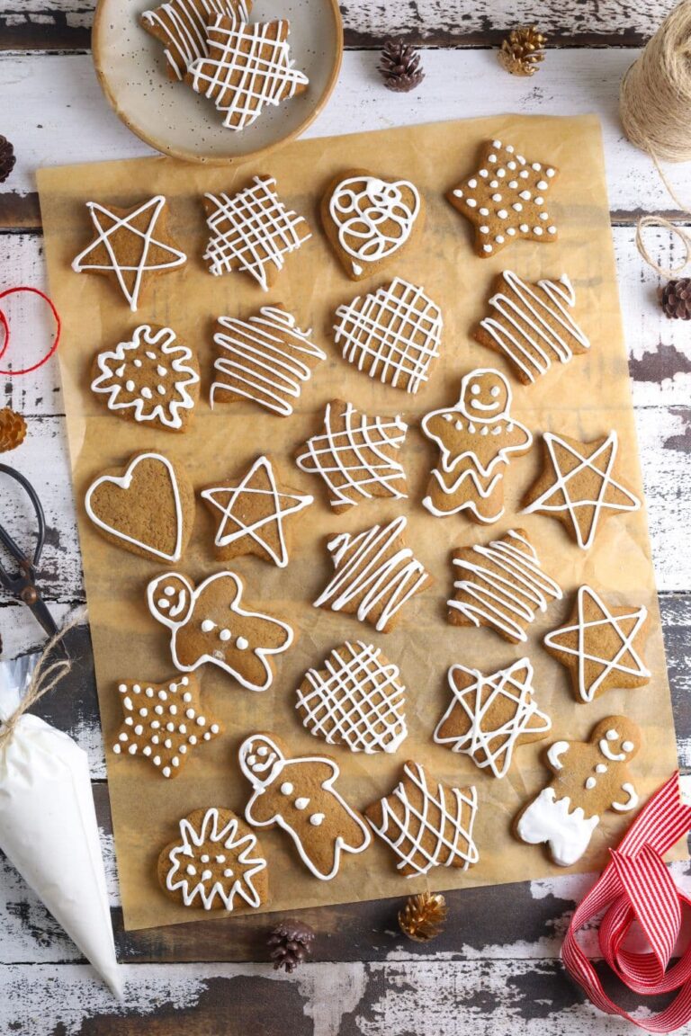 A flat lay of lots of different sourdough gingerbread cookies that have been decorated with white royal icing.