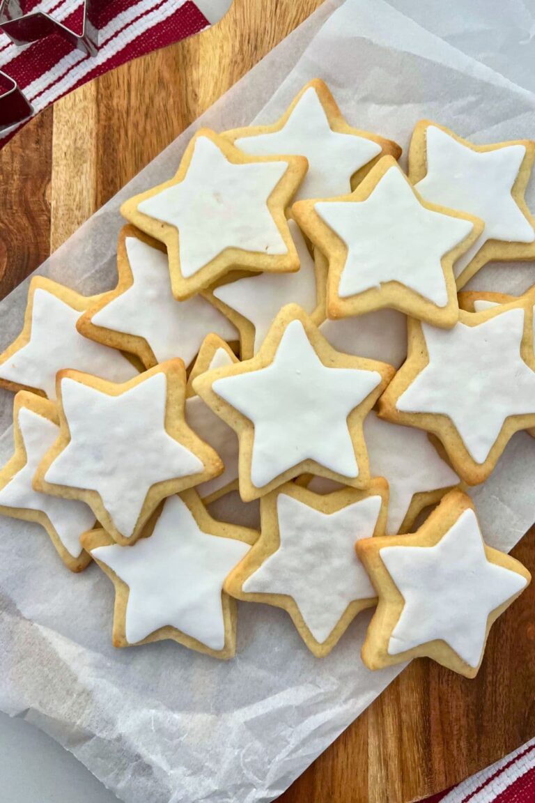 Sourdough Sugar Cookies in the shape of stars with white fondant on them. There is a red and white dish towel in the background.