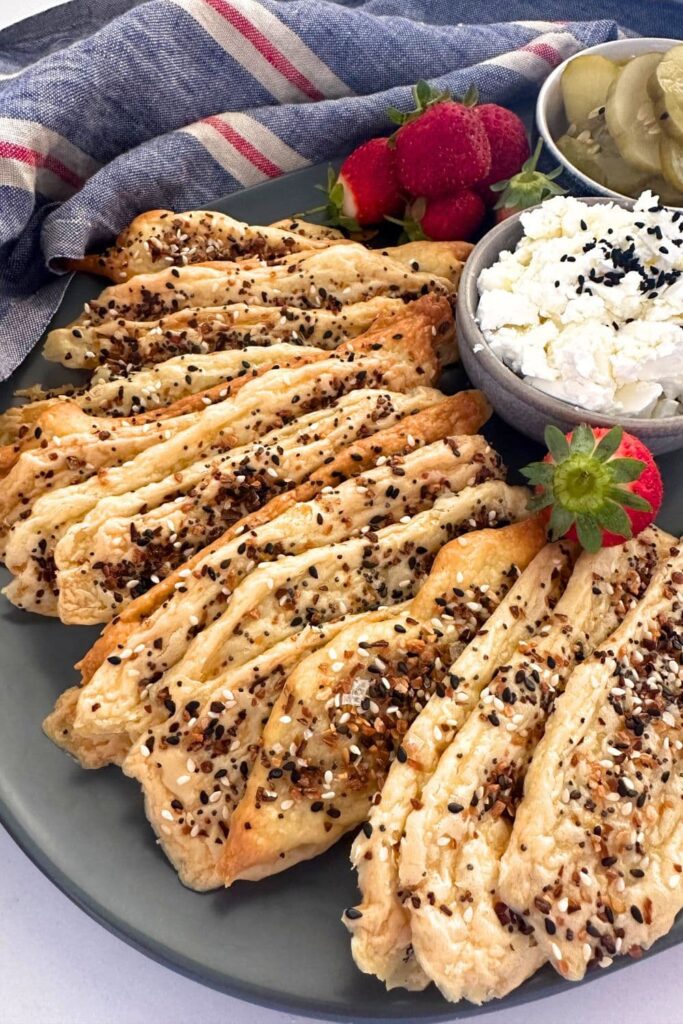 2 ingredient sourdough discard crackers laid out on a platter along with some dip and strawberries.