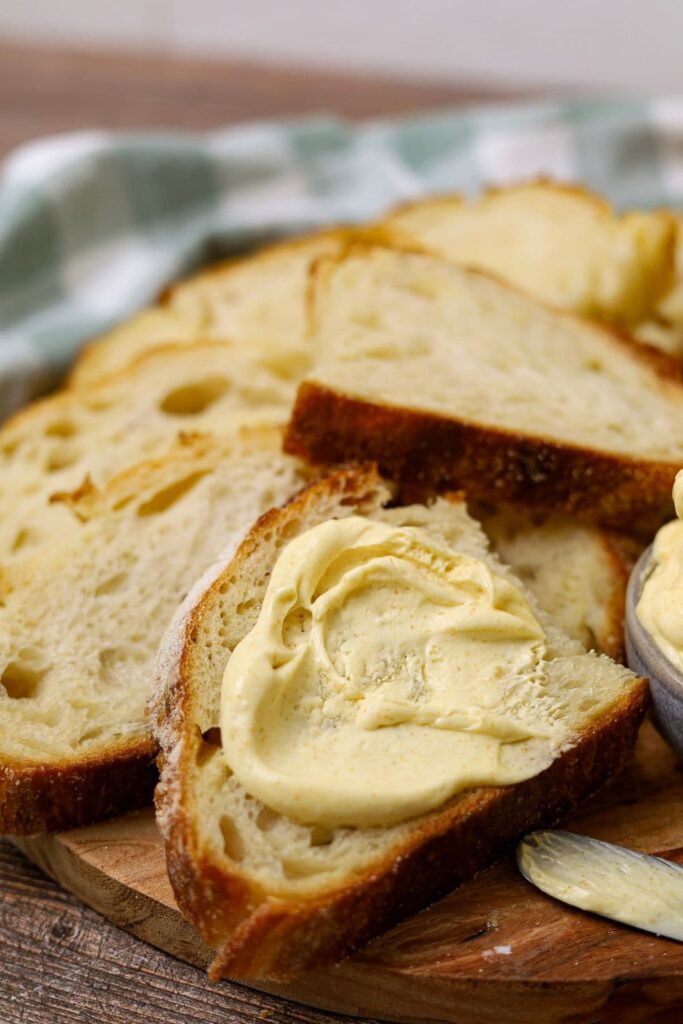 Slices of sourdough croissant bread that have been spread with butter.