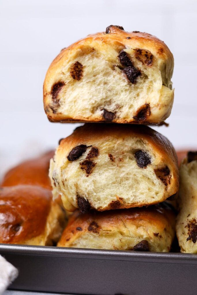 A close up image of two sourdough chocolate chip brioche rolls that are stacked on top of one another.