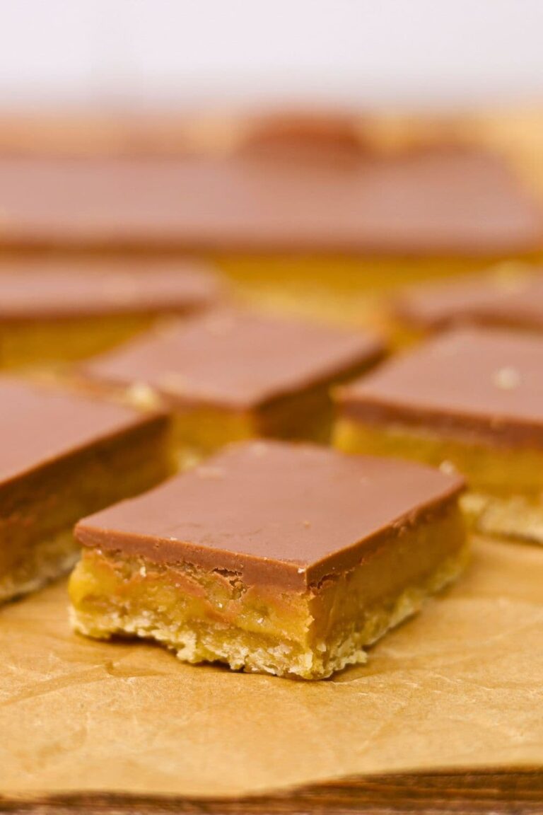 A close up image of a piece of sourdough caramel slice showing the gooey caramel inside.