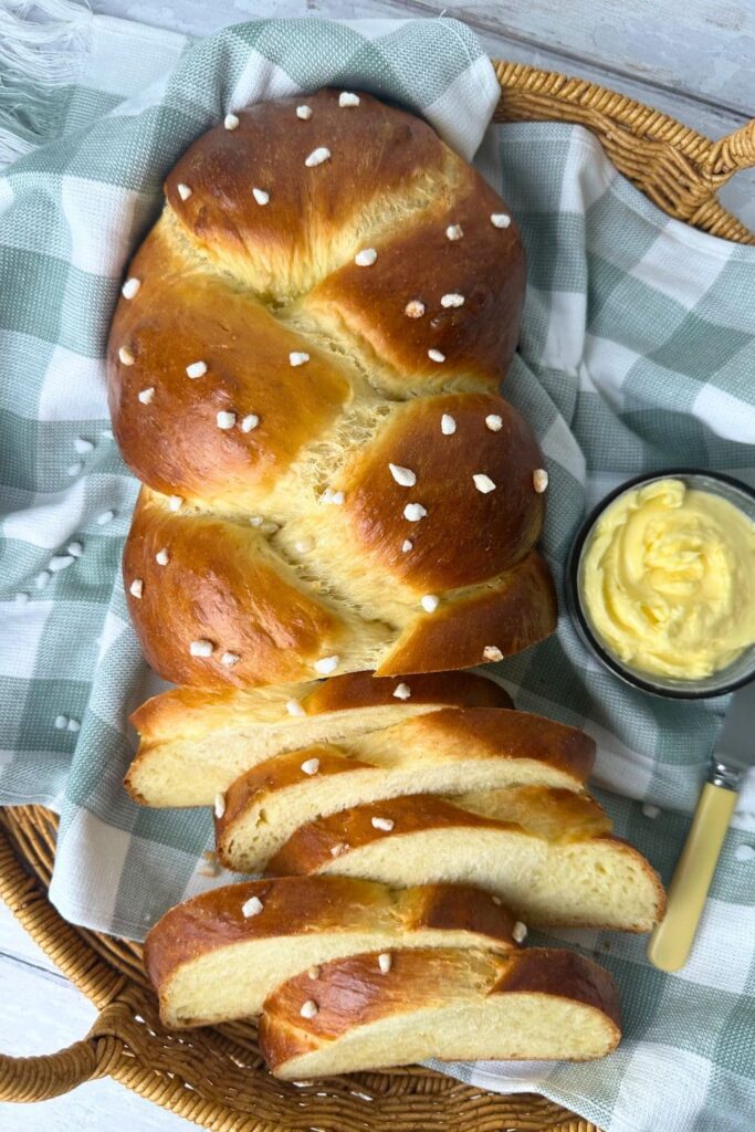 Top down view of a sweet braided sourdough loaf. Half of the loaf has been sliced while the other half is intact.