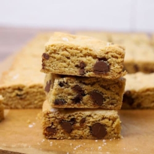 A stack of 3 sourdough chocolate chip cookie bars displayed to show their soft, chewy centres laden with chocolate chips.