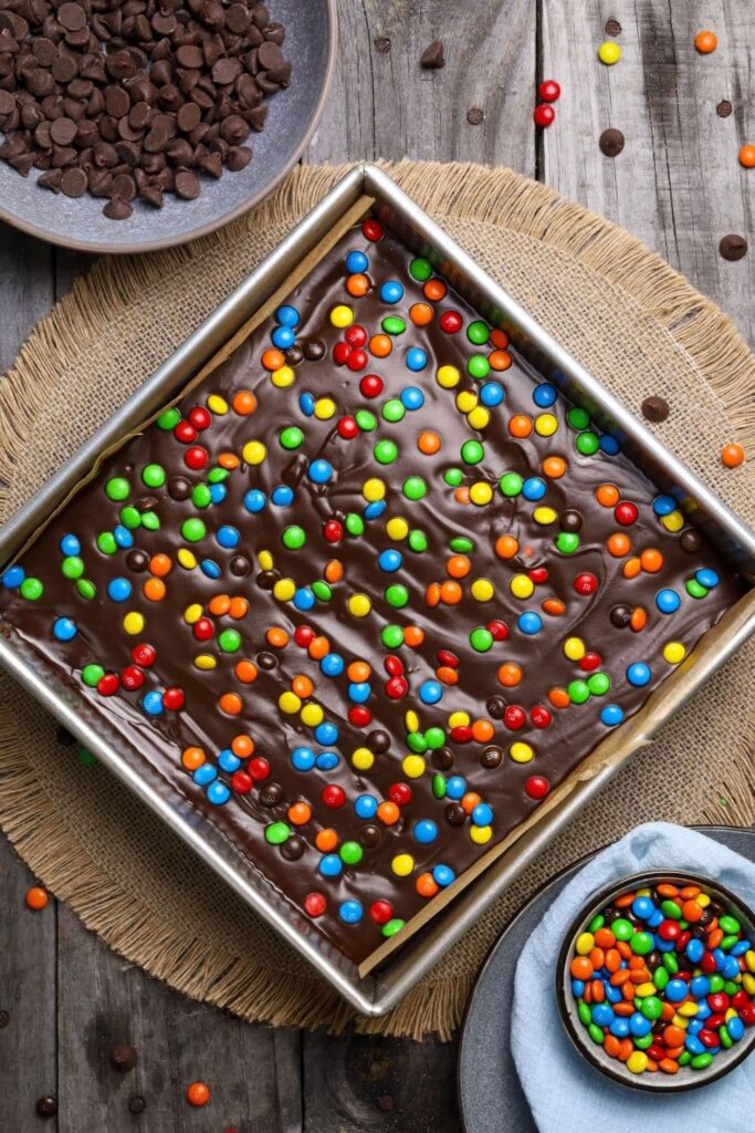 Sourdough cosmic brownies with ganache topping and candies on a placemat.