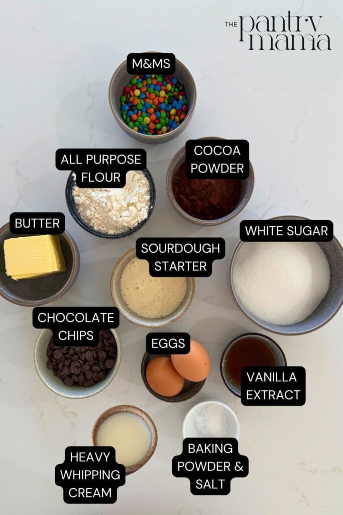 A batch of sourdough cosmic brownies topped with rainbow m&ms and cut into squares.