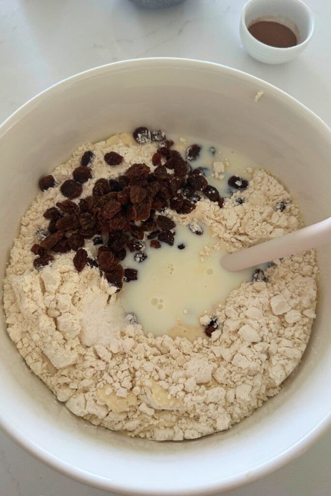 Sourdough discard cinnamon raisin English muffins added to bowl to be mixed.