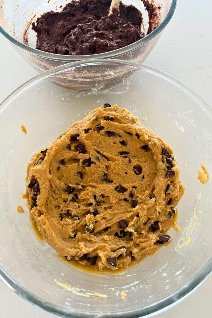 A bowl of sourdough chocolate chip cookie dough sitting on a counter top.