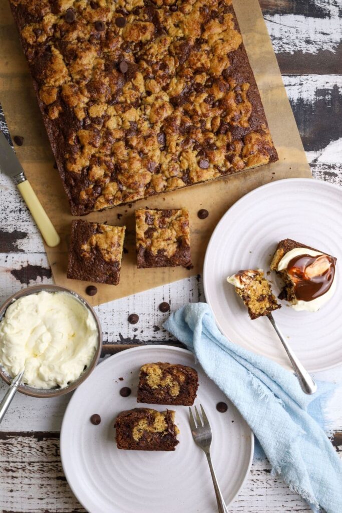 Flat lay photo taken from above of sourdough brookies. There are two white plates with small pieces of sourdough brookies on it with small forks.