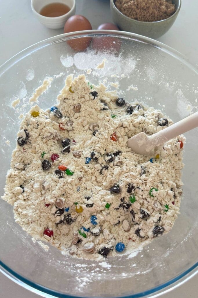 Dry ingredients mixed in bowl with a spoon for sourdough monster cookies.