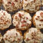 A whole batch of maple pecan sourdough oatmeal cookies with maple butter glaze on a wire cooling rack.