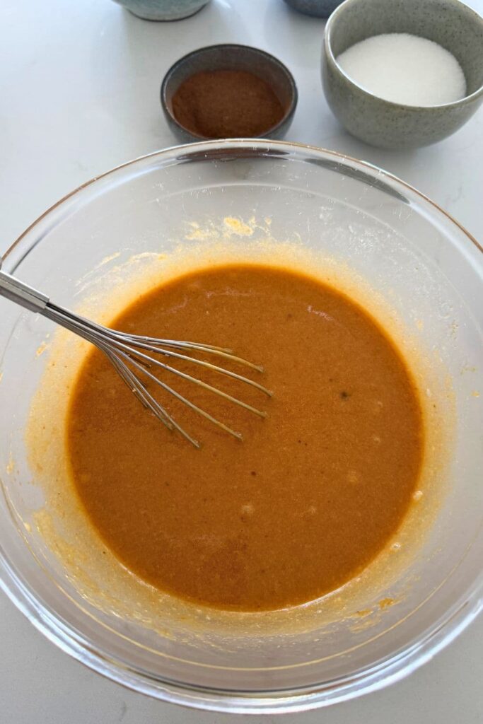 Wet ingredients for sourdough pumpkin chocolate chip cookies in a mixing bowl.