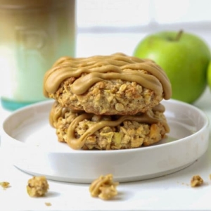 Two sourdough apple cinnamon oatmeal cookies stacked on a plate for serving.