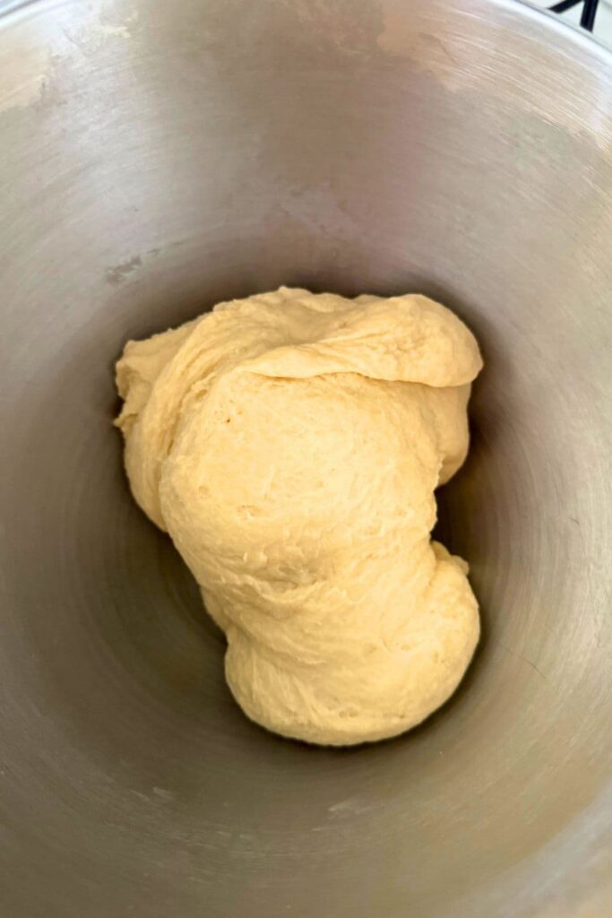 Smooth sourdough burger bun dough after mixing in bowl.