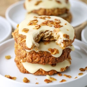 A small stack of sourdough honey oat cookies topped with honey butter glaze and toasted oats.