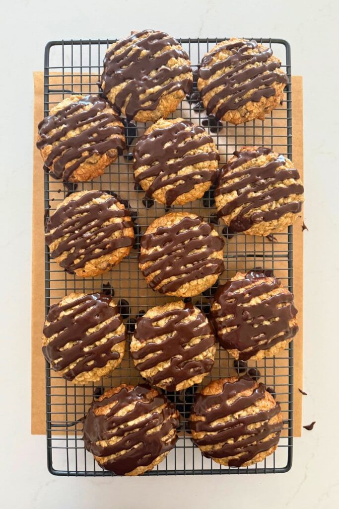 Sourdough Oatmeal Chocolate Chip Cookies on a wire cooling rack with chocolate glaze on top.