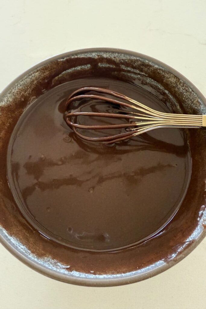 Chocolate glaze just mixed in a bowl for Sourdough Oatmeal Chocolate Chip Cookies.