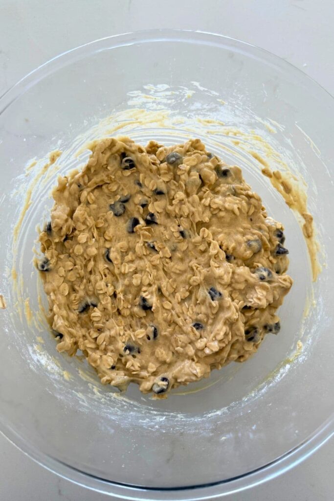 Mixed cookie dough in a bowl for Sourdough Oatmeal Chocolate Chip Cookies.