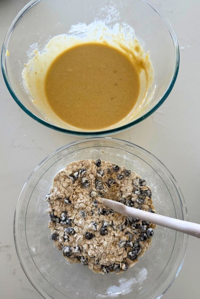 Bowl of mixed wet ingredients next to a bowl of mixed dry ingredients to make Sourdough Oatmeal Chocolate Chip Cookies.