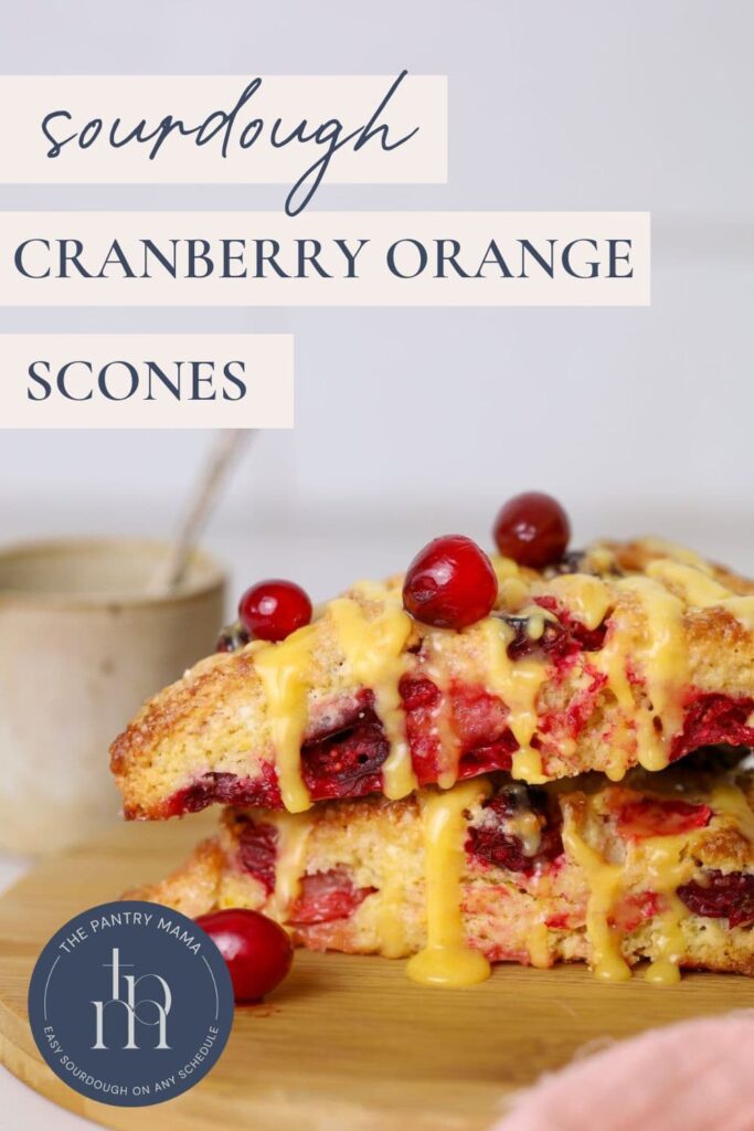 Pinterest Pin for sourdough orange and cranberry scones showing text overlay and two scones stacked on wooden plate.