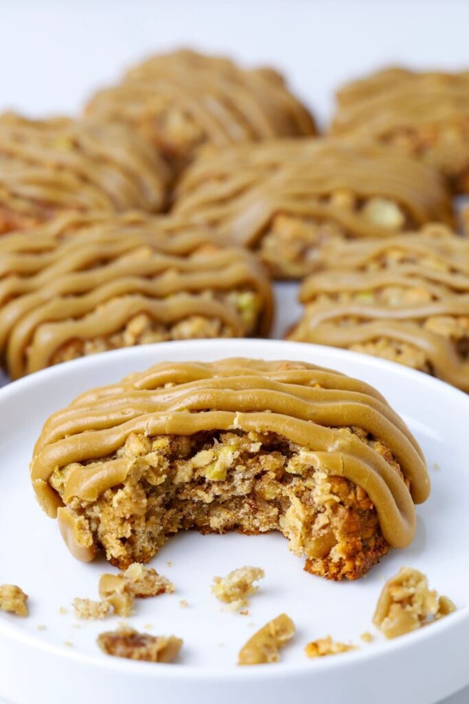 Close up of apple cinnamon sourdough oatmeal cookie on a plate with a bite taken out.