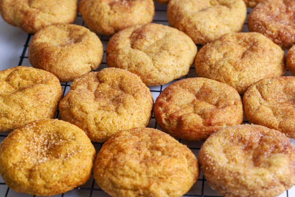 Close up of sourdough pumpkin snickerdoodles cooling on a wire rack.
