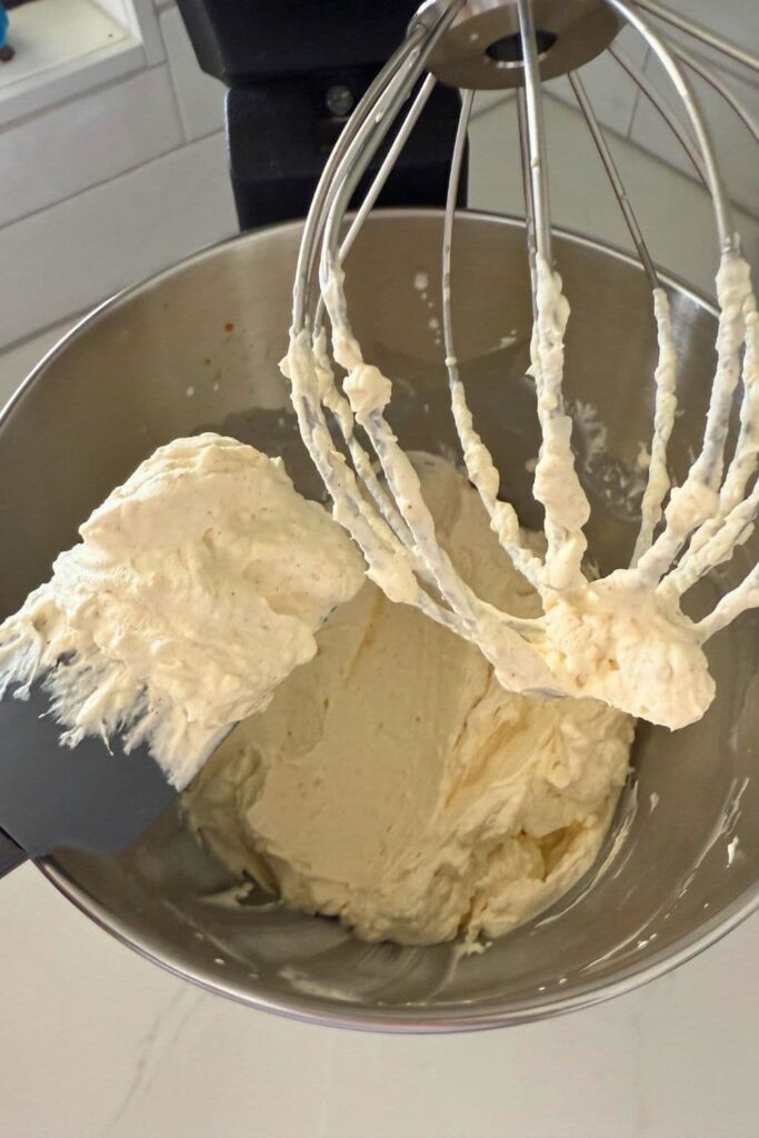 Mixing cream crease and heavy whipping cream in a stand mixer to make whipped caramel dip.