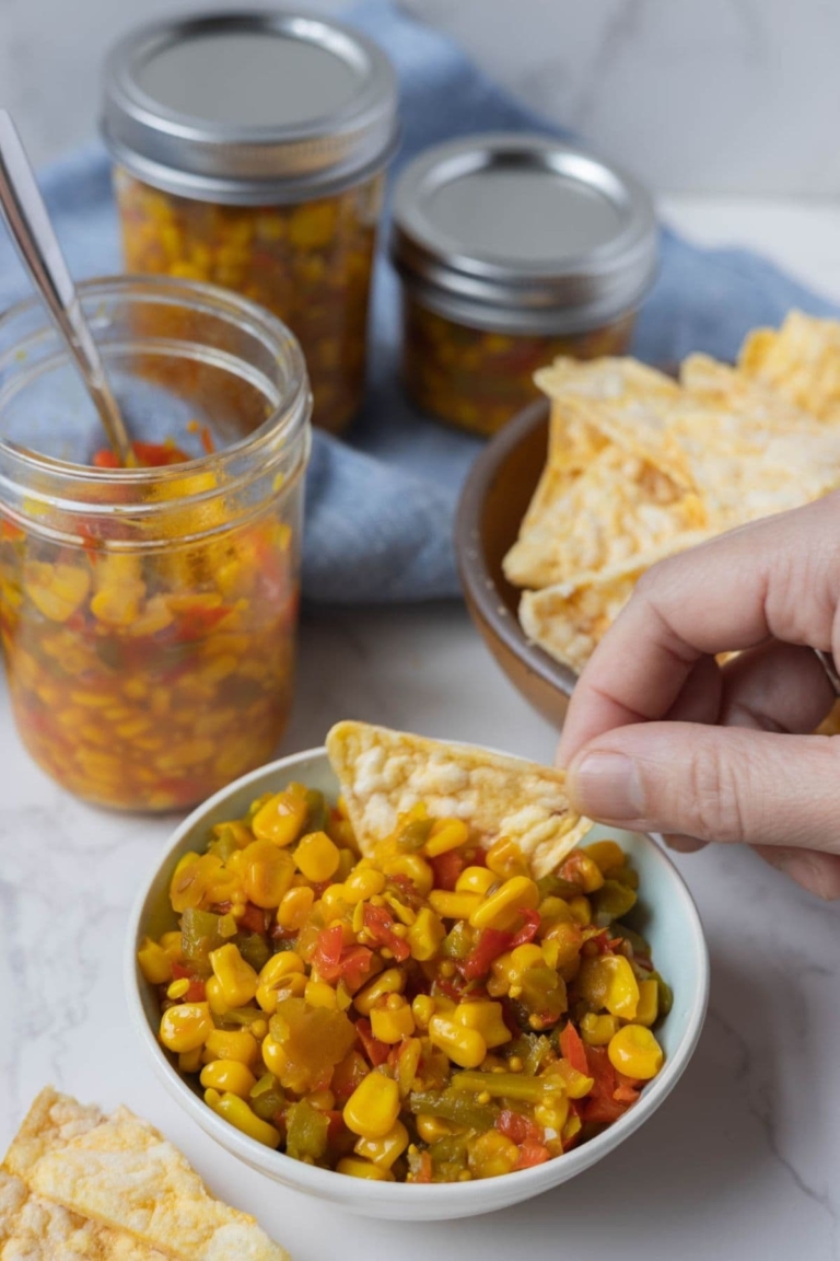 Dipping chips into a bowl of corn relish.